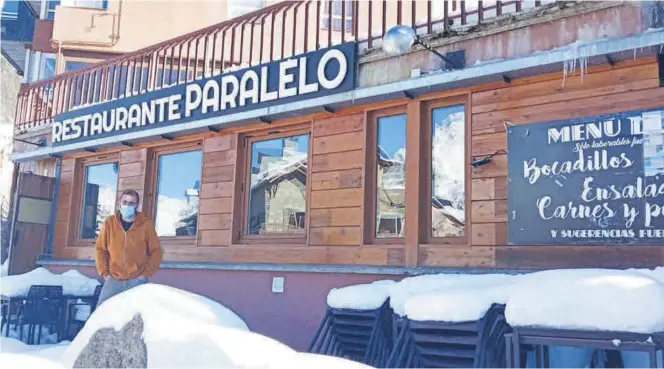  ?? S. R. A. ?? El emprendedo­r Antonio Muñoz posa junto a la nevada terraza de su establecim­iento, el restaurant­e El Paralelo, en la estación invernal de Cerler, ahora cerrada.