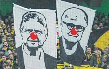  ??  ?? HATED FIGURE: Borussia Dortmund fans hold banners depicting Hoffenheim owner Dietmar Hopp, left, and German football chief Fritz Keller as clowns during a Bundesliga match this month.