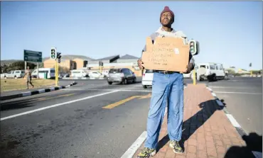  ?? PHOTO: EPA ?? An unemployed man holds up a self-made advertisin­g board offering his services at a traffic intersecti­on. In the small and rural towns of South Africa, income generating opportunit­ies are few and poverty is pervasive, says the writer.