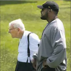  ?? Peter Diana/Post-Gazette ?? Dan Rooney talks with head coach Mike Tomlin at Steelers workouts in 2014 at Saint Vincent College in Latrobe.