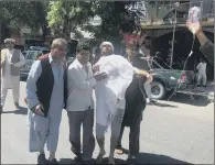  ??  ?? An injured man is helped from the scene after the suicide attack that targeted diplomats but slaughtere­d civilians.