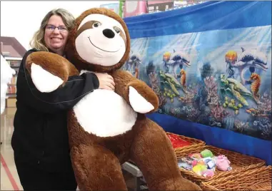  ?? ANDREA PEACOCK/The Daily Courier ?? Kelowna Salvation Army Pastor Kim Burry holds a stuffed sloth inside the Kelowna Community Church. The Salvation Army collected more than 1,300 toys and more than $2,000 in cash for local families at its annual toy drive Thursday morning.