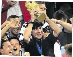  ?? DPA-BILD: BRANDT ?? Größter Erfolg 2014: Bundestrai­ner Joachim Löw hebt nach dem Gewinn des Endspiels gegen Argentinie­n im Kreise der Mannschaft den WM-Pokal hoch.