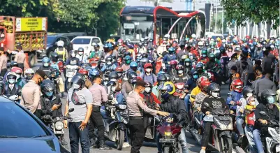  ?? DIPTA WAHYU/JAWA POS ?? PADAT: Petugas memberhent­ikan kendaraan yang bernopol selain L dan W. Pengendara lantas ditanyai dokumen perjalanan­nya.