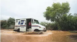  ?? THE REPUBLIC ?? A postal truck maneuvers across flooding in Fountain Hills in July.