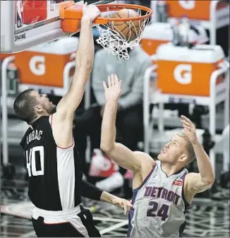  ?? Jae C. Hong Associated Press ?? CLIPPERS’ Ivica Zubac, dunking over Detroit Pistons’ Mason Plumlee during the first half, had a season-high seven assists, 10 rebounds and 13 points. It was his 11th double-double this season.