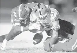  ?? MICHAEL LAUGHLIN/SUN SENTINEL ?? Palm Beach Gardens’ Adrian Santiago fumbles the ball against Deerfield Beach during the first half of the teams’ Class 8A playoff game Friday night. Deerfield Beach won 53-9.