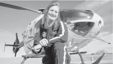  ?? STEVE HELBER/AP ?? Air ambulance flight paramedic Rita Krenz poses in front of her company’s helicopter in Weyers Cave, Virginia. Krenz started a fundraisin­g campaign that brought in more than $18,000 that has helped RIP Medical Debt forgive the debt of more than 900 people.