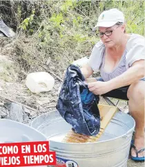  ??  ?? COMO EN LOS
VIEJOS TIEMPOS
Carmen Bonilla lava la ropa a mano en una charca cerca de su casa.