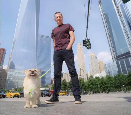  ?? PATRICK SISON/THE ASSOCIATED PRESS ?? Dion Leonard and his dog, Gobi, pose for a photo in New York. During a 155-mile race across the Gobi Desert, the dog sought out the ultra-runner, who seems genuinely baffled by it all. He marvels at Gobi’s ease crossing the Tian Shan mountain range and...