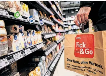  ?? FOTO: OLIVER BERG/DPA ?? Ein Kunde kauft digital und teils ohne Personal ein – der Einkauf im Supermarkt ist im Umbruch.