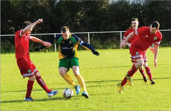  ??  ?? Lee Salter for Crettyard goes through a gap between Paul Barr and Paul O’Reilly of Enniskerry.