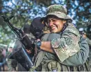  ?? FEDERICO RIOS ESCOBAR FOR THE NEW YORK TIMES ?? Long-separated Colombian rebels greeting each other in a settlement zone.