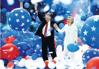  ?? (AP FOTO) ?? OFFICIAL CANDIDATES. Democratic vice presidenti­al candidate Sen. Tim Kaine and Democratic presidenti­al candidate Hillary Clinton walk through the falling balloons during the final day of the Democratic National Convention in Philadelph­ia.