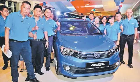  ??  ?? Photo shows staff of Gamma Automobile during the launch of the Perodua Bezza on Thursday night.