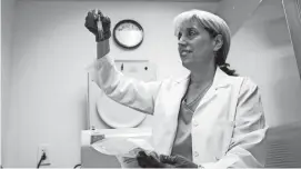  ?? DAKE KANG/AP ?? Stephanie Richurk, a nurse at the University of Pittsburgh Medical Center, holds up a blood sample collected from a participan­t in the “All of Us” research program in Pittsburgh.