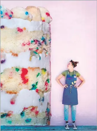  ?? Photos from Milk Bar ?? PASTRY CHEF Christina Tosi, above, checks out a blown-up image of her birthday cake on the wall outside her new Milk Bar shop, below, also a production kitchen and distributi­on center.