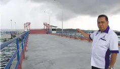  ??  ?? Kudat district officer Sapdin Ibrahim pointing at the Kudat-Palawan ferry terminal in Kudat. - Bernama photo