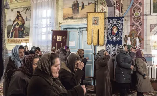  ?? BRENDAN HOFFMAN NYT ?? Parishione­rs worship at St. Michael’s Church in Chernytsya, Ukraine, in December.