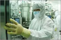  ??  ?? In the COVID-19 vaccine stock solution workshop, a staff member checks the reactor setting parameters on July 15.