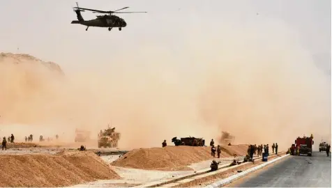  ?? Foto: Javed Tanver, afp ?? Nach dem Anschlag auf einen Nato Konvoi sondiert ein Hubschraub­er die Lage von der Luft aus, während Soldaten das Gebiet mit ihrer Waffe im Anschlag sichern. Ein Au genzeuge berichtete von mindestens drei Todesopfer­n.