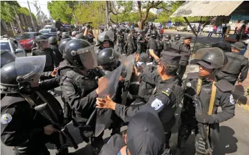  ??  ?? Riot police arrive at a parking lot where opposition protesters demonstrat­ing against the government took refuge as police warned they will arrest anyone who ‘alters peace and coexistenc­e’, in Managua.