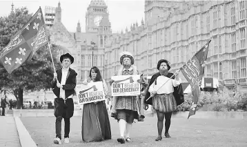  ??  ?? Protesters dressed in Tudor costume including one dressed as King Henry VIII hold signs protesting elements of the European Union Withdrawl Bill that is being debated by lawmakers in the House of Commons in London on September 7. The introducti­on of...