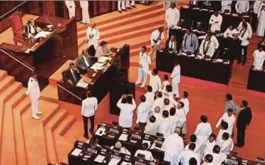  ?? REUTERS PIC ?? Members of parliament arguing in front of Speaker Karu Jayasuriya at Parliament in Colombo yesterday.