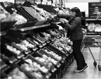  ??  ?? A shopper selects fruit at the Asda superstore in High Wycombe, Britain.The rise in inflation in Britain after the Brexit vote has made households the most downbeat about their finances in more than two years, and the giant services sector is also...