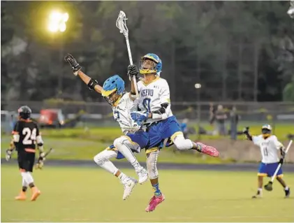  ?? KENNETH K. LAM/BALTIMORE SUN ?? Mervo’s Tayquan Busby, left, celebrates with teammate Charles Pitt after Pitt’s goal in the fourth quarter. Pitt was a close friend of City junior captain Ray Glasgow III, who was killed Saturday night, and honored him by wearing his No. 10 jersey.