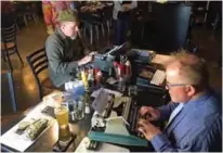  ??  ?? Joe Van Cleave, left, and Rich Boucher, right, try out various vintage typewriter­s at a "type-in" in Albuquerqu­e, NM.