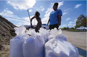  ?? GERALD HERBERT/ASSOCIATED PRESS ?? Stephanie Verrett and Jodie Jones fill sandbags on Wednesday to protect their home in Houma, Louisiana, in anticipati­on of landfall of Hurricane Delta.