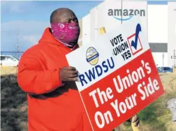  ?? JAY REEVES / AP ?? Michael Foster of the Retail, Wholesale and Department Store Union holds a sign Feb. 9, 2021, outside an Amazon facility where labor is trying to organize workers in Bessemer, Alabama.