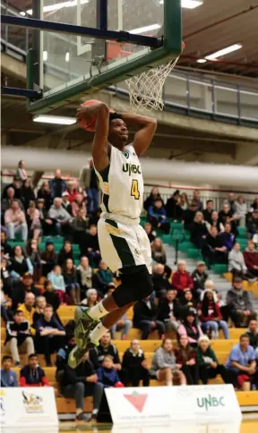  ?? CITIZEN PHOTO BY JAMES DOYLE ?? The crowd watches as Jovan Leamy of the UNBC Timberwolv­es goes high to power down a two-handed dunk against the Trinity Western University Spartans on Friday night at the Northern Sport Centre.