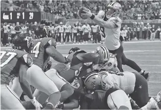  ?? AP PHOTO/CURTIS COMPTON ?? New Orleans Saints quarterbac­k Drew Brees leaps over the pile at the line of scrimmage for the winning touchdown in a 43-37 overtime victory against the Falcons on Sept. 23 in Atlanta. The NFC South rivals meet again tonight in New Orleans, with the Saints trying to run their winning streak to 10 games and the Falcons trying to pull off an upset and keep their slim playoff hopes alive.