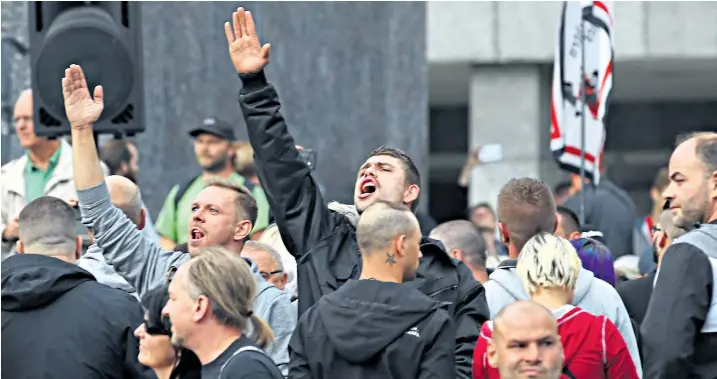  ??  ?? Protesters appear to give the Nazi salute, which is banned in Germany, during demonstrat­ions after the fatal stabbing of a man in the eastern city of Chemnitz. Left-wing and Right-wing groups confronted each other as riot police attempted to quell violence