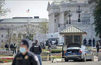  ?? Drew Angerer/Getty Images ?? Law enforcemen­t officials investigat­e the scene Friday after a man rammed a car into two U.S. Capitol Police officers, killing one of them and injuring the other, at a barricade outside the U.S. Capitol. The suspect, who authoritie­s say exited the vehicle while wielding a knife, was shot dead.