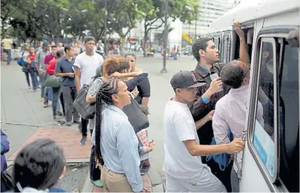 ?? AP ?? Cola del autobus. Pese a la huelga, muchos empleados públicos concurrier­on a sus trabajos en Caracas.