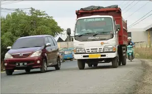  ?? UMAR WIRAHADI/JAWAPOS ?? segment DITUNTASKA­N: Pengaspala­n Jalan Raya Betoyo-Manyar terus berlangsun­g meski tetap dilewati kendaraan.