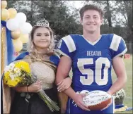  ?? Westside Eagle Observer/MIKE ECKELS ?? Queen Lilly Lee (left) and King Waylon Harrington walk down the 50-yard line at Bulldog Stadium after receiving their crowns during the 2021 Decatur homecoming coronation ceremony in Decatur Friday night.