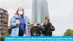  ??  ?? FRANKFURT: A woman and police officers wearing face masks are pictured in front of the European Central Bank (ECB) headquarte­r during a rally against restrictio­ns in place to limit the spread of the new coronaviru­s COVID-19 pandemic in Frankfurt am Main. —AFP