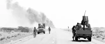  ??  ?? Yemeni fighters loyal to the Saudi-backed Yemeni president are seen with their vehicles on the road leading to the town of Khokha, 120 kilometres south of the Huthi rebel-held Red Sea port of Hodeida. — AFP photo