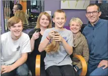  ??  ?? Megan (centre) pictured here after the head shave with her brother Owen (left), mother Louise (second right) and dad Mike (right), joined by hairdresse­r Ashleigh Fraser (second left) of Caol Cutz Hair Design.