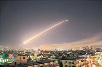  ?? HASSAN AMMAR/THE ASSOCIATED PRESS ?? The Damascus sky lights up with surface-to-air missile fire as the U.S. launches an attack on Syria early Saturday.