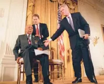  ?? DOUG MILLS/AP 1997 ?? President Bill Clinton, right, and Vice President Al Gore stand beside Tuskegee syphilis study victim Herman Shaw in Washington. Clinton apologized to Black men subjected to the study.