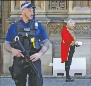  ?? (AP/Kirsty Wiggleswor­th) ?? A police officer keeps guard as an official in ceremonial dress enters Britain’s parliament Tuesday in London.