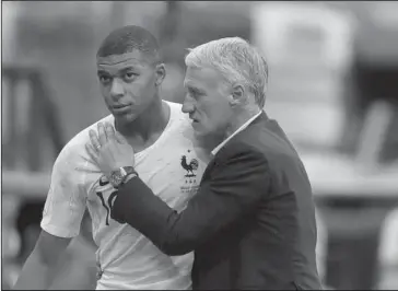  ?? The Associated Press ?? FAST FRENCHMAN: France’s Kylian Mbappe, left, is embraced by head coach Didier Deschamps as he leaves the pitch during the quarterfin­al match against Uruguay Friday in the 2018 FIFA World Cup in Nizhny Novgorod, Russia.