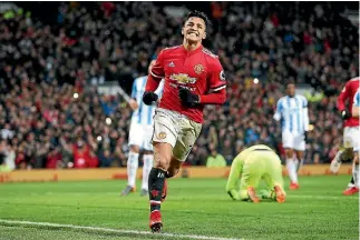  ??  ?? Alexis Sanchez celebrates scoring on his home debut for Manchester United in a 2-0 win over Huddersfie­ld Town.