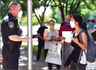  ?? NEWS-SENTINEL FILE PHOTOGRAPH ?? Charlotte Zhang, of Lodi, talks with Lodi Police Chief Sierra Brucia during a protest outside the Lodi Police Department in June of 2020. Brucia has been faced with many challenges since taking over as police chief in early 2020.