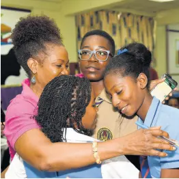  ?? IAN ALLEN/PHOTOGRAPH­ER ?? Armani Dyer (second right), a grade eight student at Ardenne High, gets congratula­tory hugs from his coach, Daunette Drummond Allen (left), schoolmate Suraiya Matandara-Clarke, and Shanece Swack from Windward Road Primary, shortly after winning The Gleaner’s Children’s Own Spelling Bee 2019 title for St Andrew.